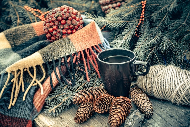 소박한 나무 테이블에 뜨거운 차 한잔. 콘, 전나무 가지 아직도 인생. 크리스마스를위한 준비.