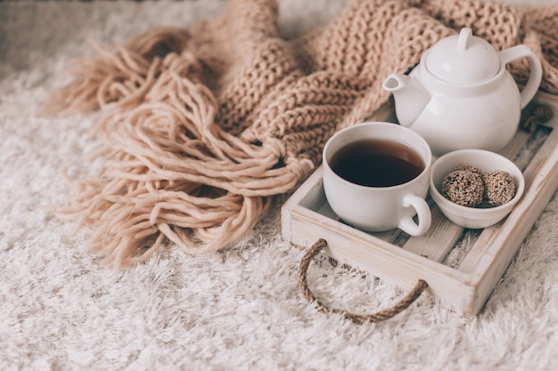 Cup of hot tea and teapot on a serving tray