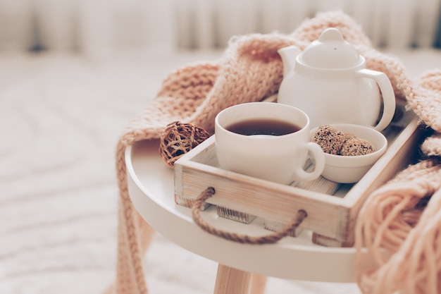 Photo cup of hot tea and teapot on a serving tray