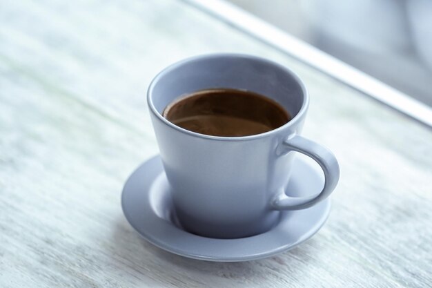 Cup of hot tea on window sill