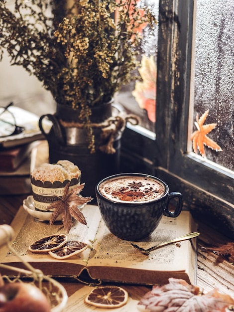 A cup of hot tea with cinnamon powder and star anise beside the window. Autumn Concept