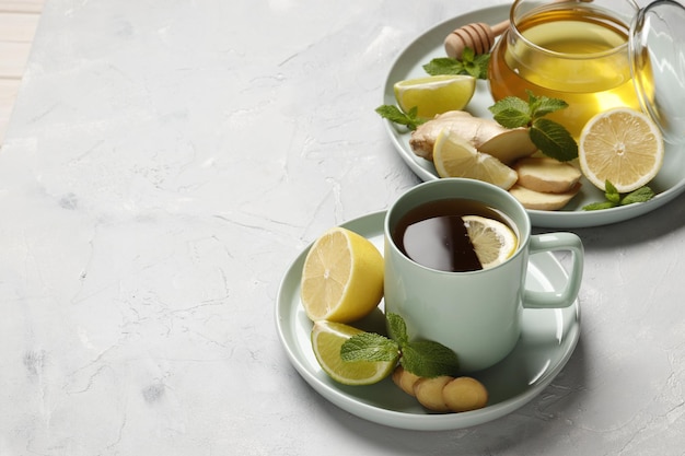 Cup of hot tea with ginger, lemon and mint isolated on a white background