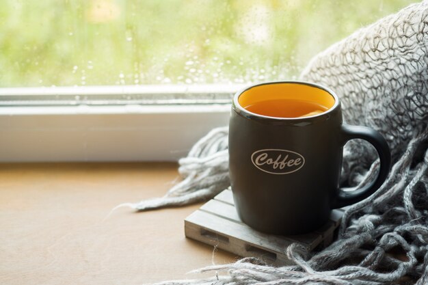 Photo cup hot tea with lemon on the windowsill woolen plaid