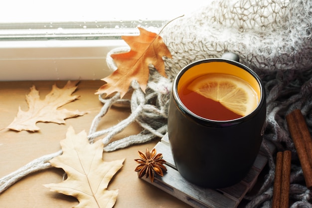 Cup hot tea with lemon on the windowsill woolen plaid