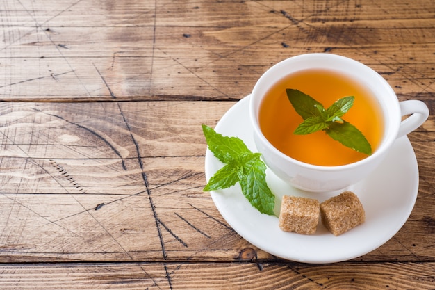 Cup of hot tea with mint and brown sugar