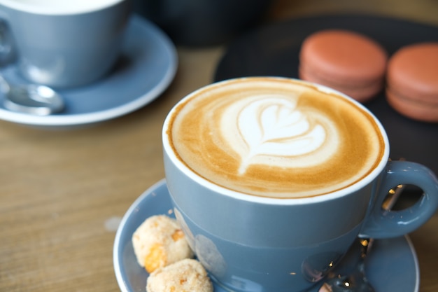 A cup of late coffee with flower shape design on top at cafe