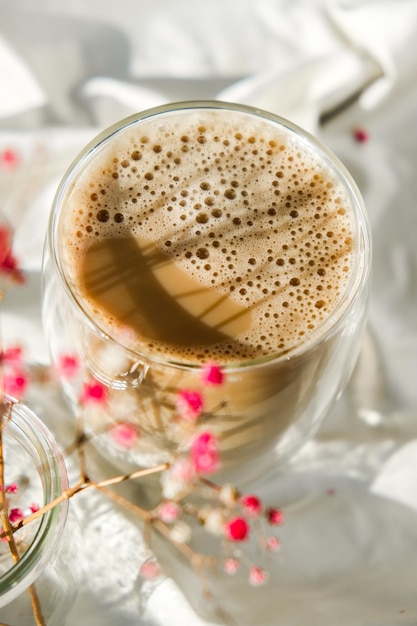 ラテカプチーノの朝のコーヒーの美学の雰囲気の朝食ピンクのカスミソウの花のカップ