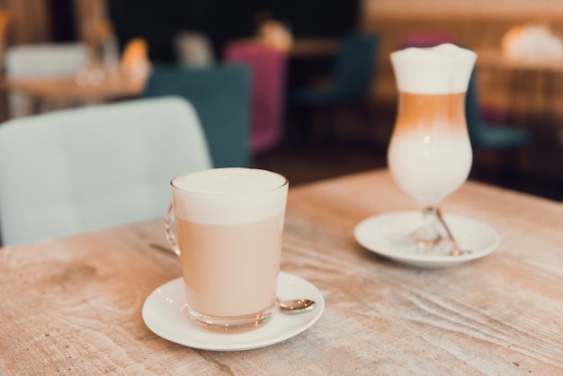 cup of latte or cappuccino on table in cafe