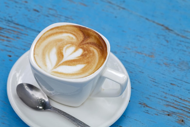 Cup of latte coffee on blue wooden