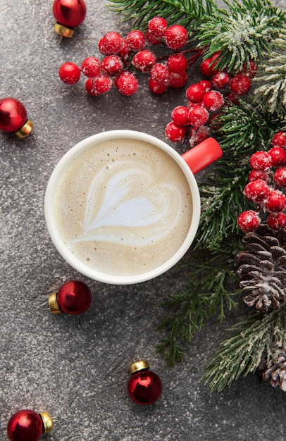 Cup of latte coffee and Christmas decoration on a dark concrete background