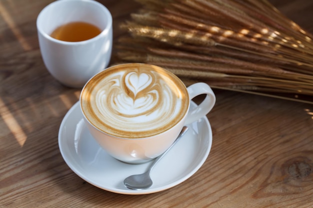 Cup of latte coffee and tea on wood table