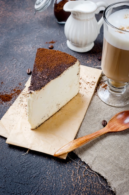 Photo cup of latte coffee with a piece of soft cheese in ground coffee