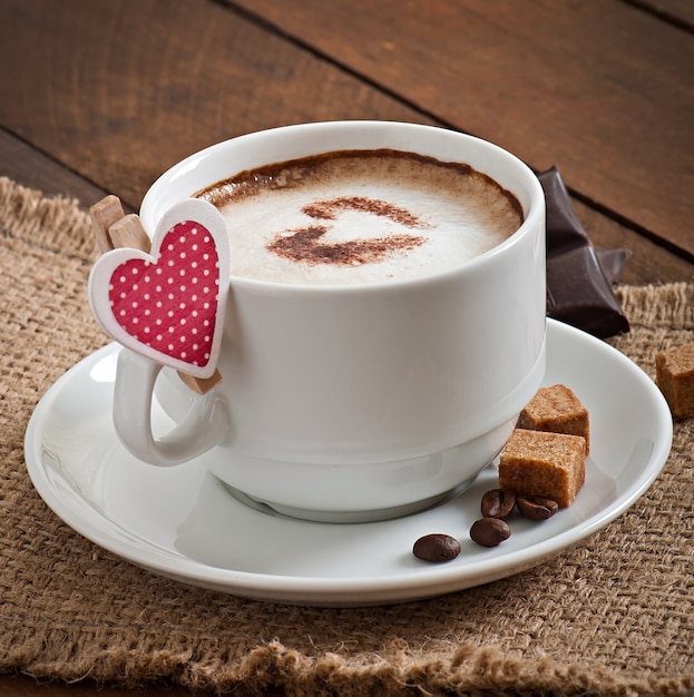 Cup of latte on the old wooden background