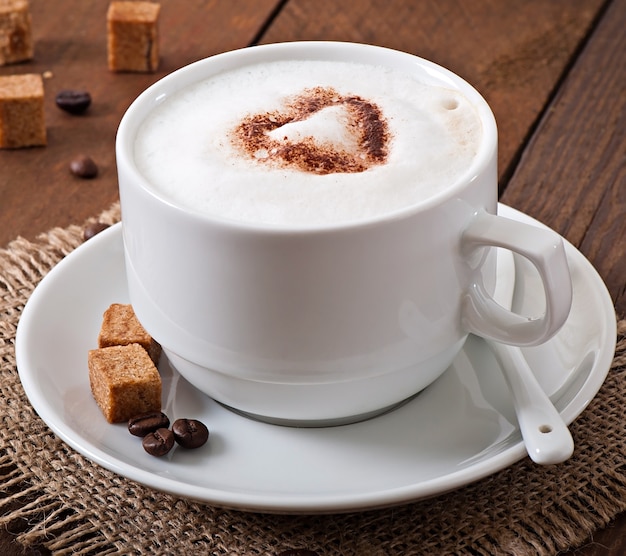 Cup of latte on the old wooden background