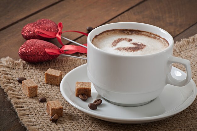 Cup of latte on the old wooden background