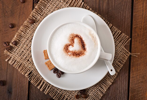 Cup of latte on the old wooden background