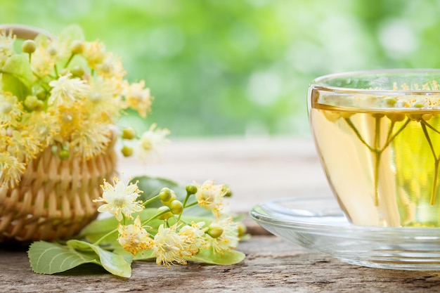 Cup of linden tea and wicker basket with lime flowers herbal medicine