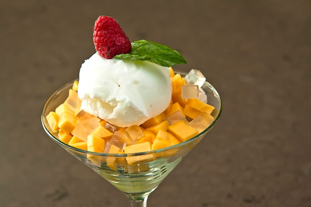 Cup of mango with lychee and raspberry ice cream stone background ice cream with fruit top view