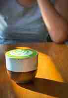 Photo cup of matcha latte green tea on wooden table with woman in background