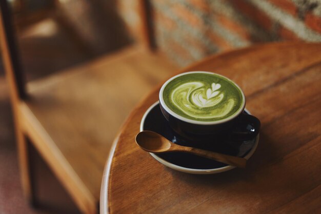 A cup of matcha latte on wooden table