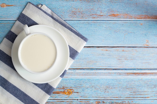 Cup of milk on kitchen table.