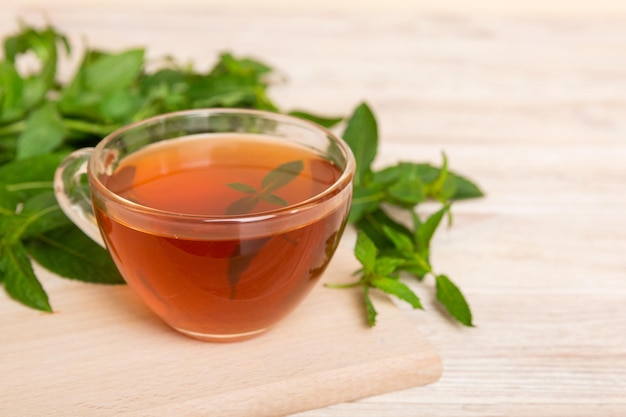 Tazza di tè alla menta sullo sfondo del tavolo tè verde con vista dall'alto di menta fresca con spazio per la copia