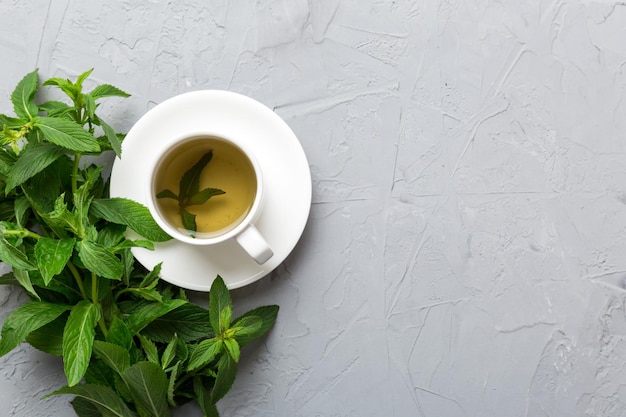 Cup of mint tea on table background Green tea with fresh mint top view with copy space