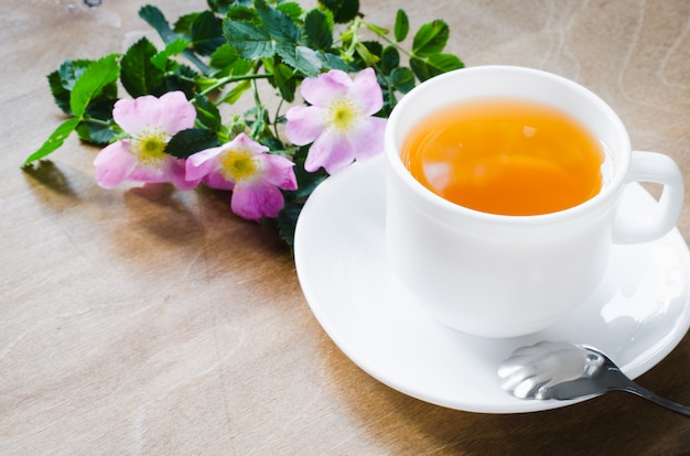 Cup of morning tea with lemon and delicate flowers