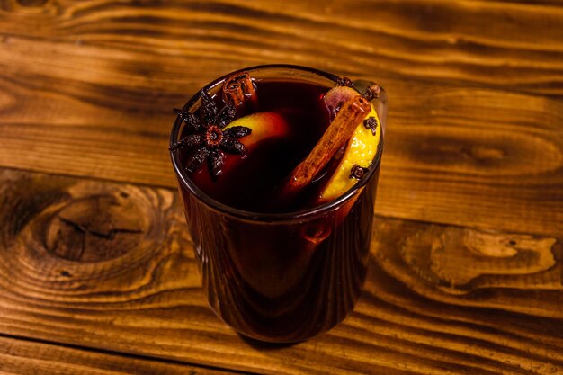 Cup of mulled wine with cinnamon on rustic wooden table