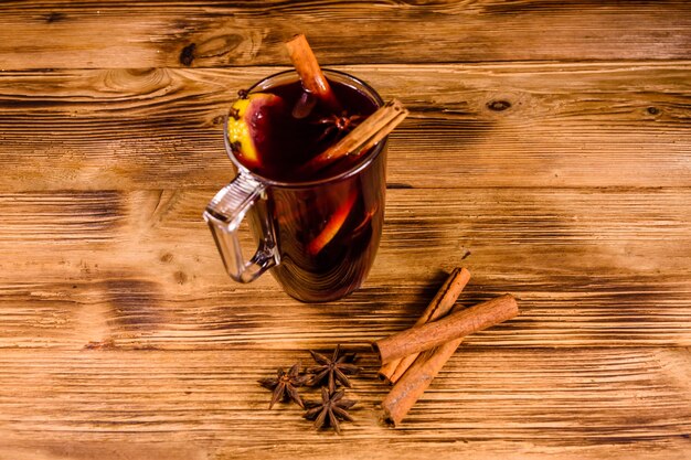 Cup of mulled wine with cinnamon on rustic wooden table