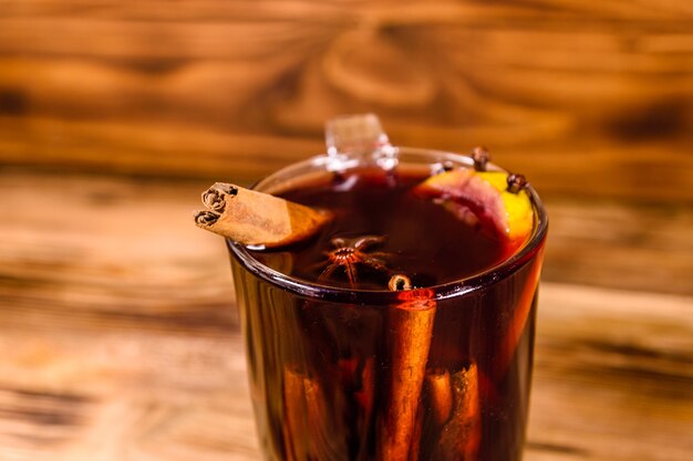 Cup of mulled wine with cinnamon on rustic wooden table