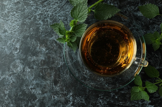 Cup of nettle tea on black smokey table