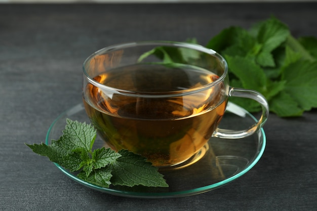 Cup of nettle tea on dark wooden table