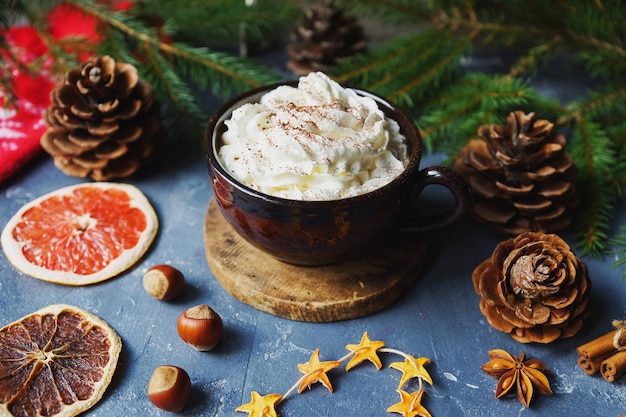 写真 ココアまたはホット チョコレート クリーム シナモン ドライ オレンジ暖かいミトンとモミの木暗い石のテーブル クリスマスの装飾居心地の良い冬の家の背景の選択と集中