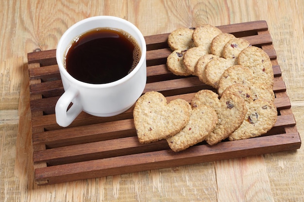 https://img.freepik.com/premium-photo/cup-of-coffee-and-tasty-cookies-in-the-shape-of-a-heart-on-old-wooden_288431-6295.jpg