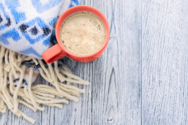 写真 一杯のコーヒーと木製のテーブルに青の模様の暖かい毛布。