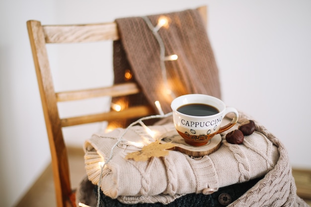 写真 秋と冬の居心地の良いレジャーのコンセプトを背景にニットベージュのチェック柄とコーヒーのカップ