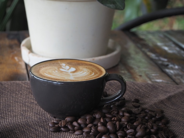 Фото Чашка кофе с красивым латте-арт. кофейная чашка с латте-арт на деревянном столе.