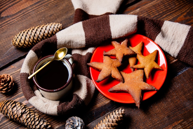 Фото Чашка кофе с печеньем и шарф на деревянный стол