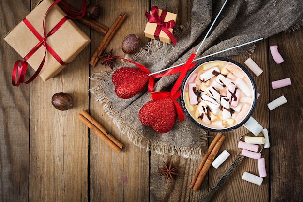 Фото Чашка горячего какао или шоколада с зефиром на деревянный стол.