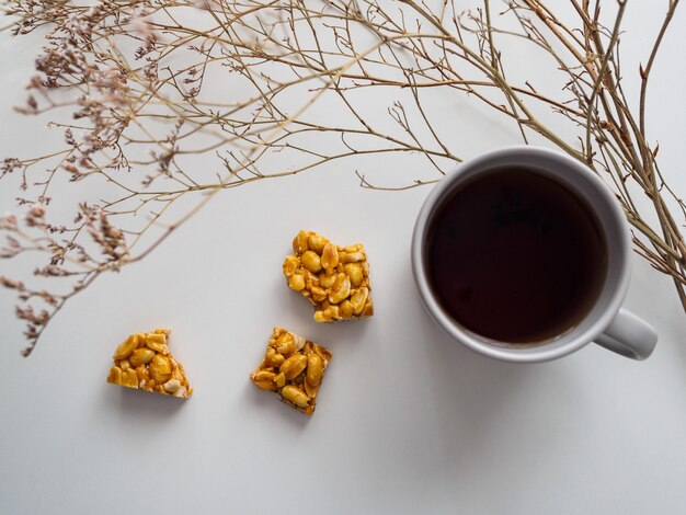 一杯のお茶、ピーナッツコジナック、白のドライフラワー。