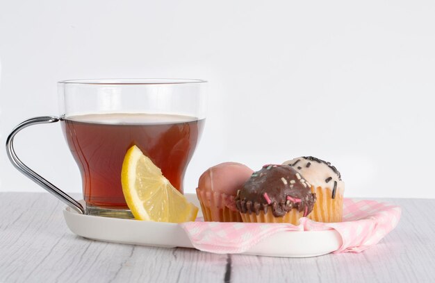 사진 다양한 맛과 색의 작은 컵케이크와 함께 레몬 <unk>으로 차 한 잔