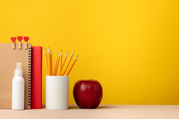 Cup of pencils and notepads on desk front view