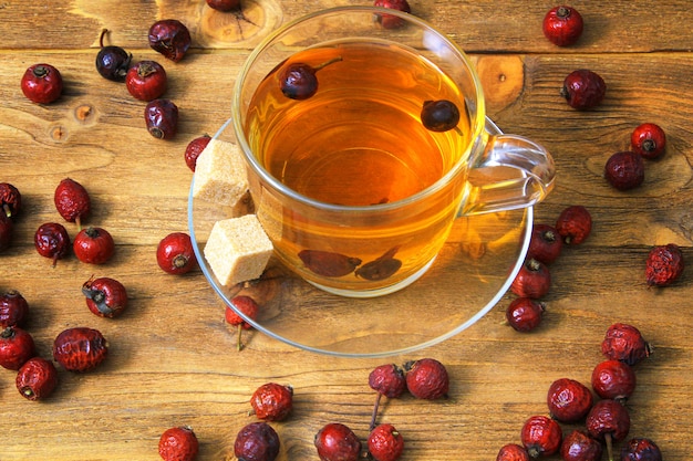 A cup of rosehip tea on a wooden table.