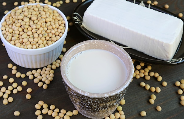 Cup of Soy Milk with Soft Tofu Bean Curd and Dried Soybeans Pile in the Backdrop