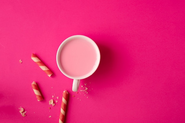 Cup of strawberry milk on pink.