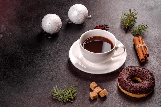 A cup of strong coffee on the Christmas table with spruce twigs and toys. Preparing for the holiday