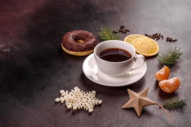 A cup of strong coffee on the Christmas table with spruce twigs and toys. Preparing for the holiday