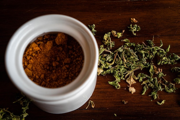 Cup of sugar and dried leaves on a wooden table