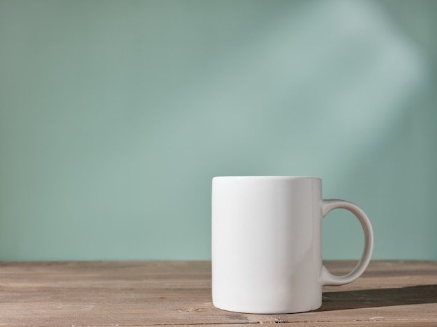 Cup on the table against the background of a green wall